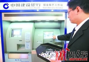 银行工作人员在演示使用自助硬币存取款机