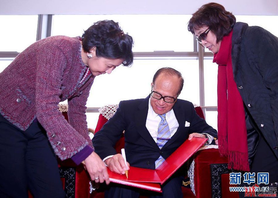 李嘉诚（中）和长江商学院首届毕业生见面后题词留念
