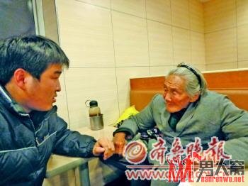 好心人张先生帮老人买了汉堡，还和老人交谈。　