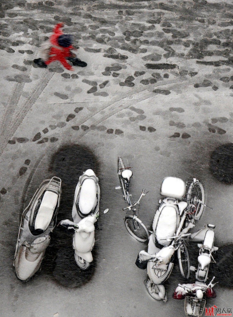 一位郑州市民冒雪走出住宅小区