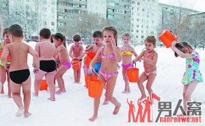 孩子们穿着泳装，拎着水桶，在雪地里玩耍。