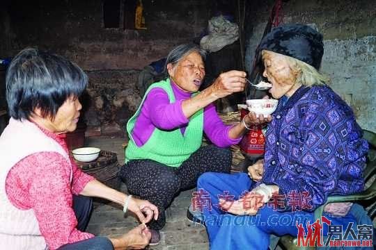 两个女儿在给彭阿婆喂粥