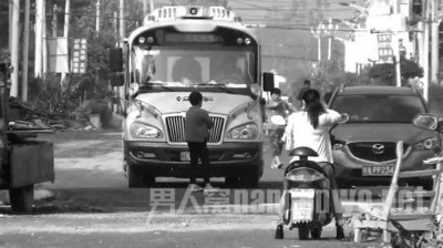 　一女子站在校车前不让走